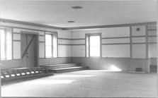 SA0476 - Meeting house interior showing corner with benches and doorway. Photo associated with the Church Family. Identified on the back.